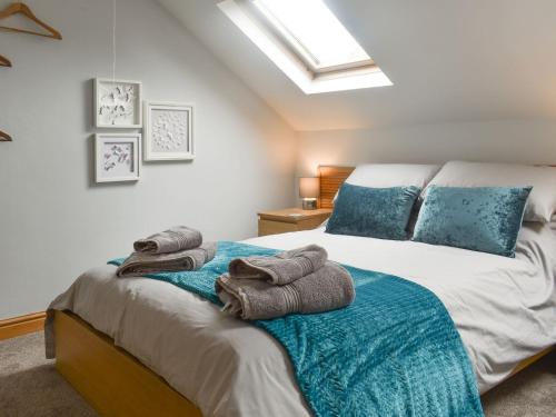 a bedroom with two beds with towels on them at Waterside Cottage in Winewall