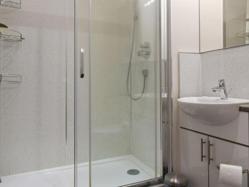 La salle de bains est pourvue d'une douche et d'un lavabo. dans l'établissement Waterside Cottage, à Winewall