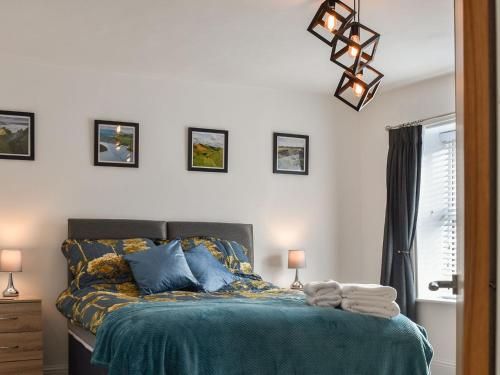 a bedroom with a bed with a blue comforter at Derwent Apartment in Glossop