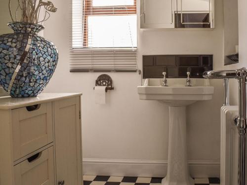 a bathroom with a sink and a vase at Byeways - Railway Carriage in Selsey