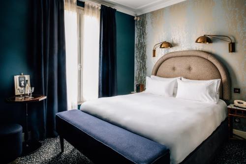 Un dormitorio con una gran cama blanca y una ventana en Grand Pigalle Hotel, en París