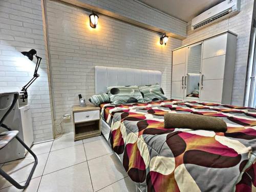 - une grande chambre avec un grand lit et une lampe dans l'établissement Bright cozy studio 1BR Cityview, SmartTV,FAST Wifi at Greenbay Pluit, à Jakarta