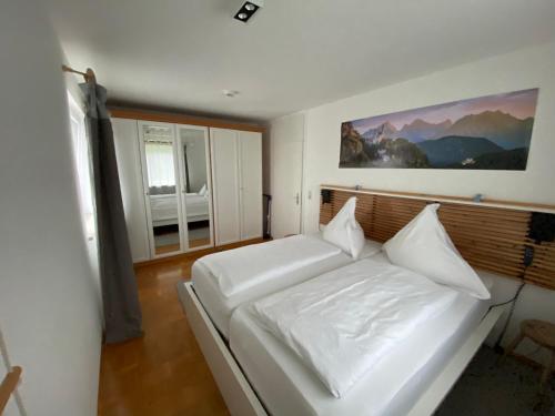 a bedroom with a white bed and a window at Ludwigslust - Ferienappartement mit Bergblick in Schwangau