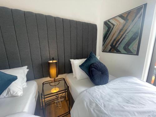 a bedroom with two beds and a large headboard at Sapphire Premier Apartments w/Secure Parking in Cardiff