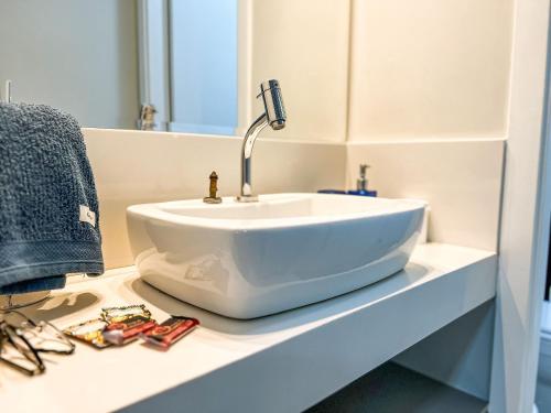 a white sink sitting on a counter in a bathroom at Condomínio Residencial Unique Residence - São José do Rio Preto in Sao Jose do Rio Preto