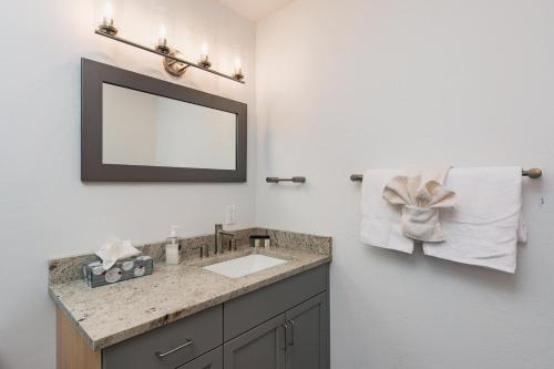 ein Badezimmer mit Waschbecken, Spiegel und Handtüchern in der Unterkunft Studio Purgatory Townhome 104 in Durango Mountain Resort