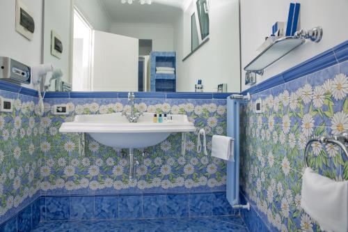 a bathroom with a white sink and blue tiles at Relais Maresca Luxury Small Hotel & Terrace Restaurant in Capri