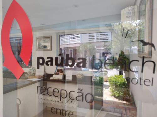 a window with the word palaña and a red sign at Paúba Beach Hotel in Pauba