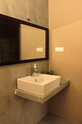 a bathroom with a white sink and a mirror at AHAS GAWWA Boutique in Padukka