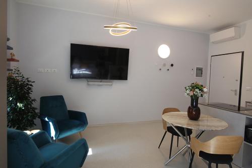 a living room with a table and chairs and a tv at Romantic Verona in Verona
