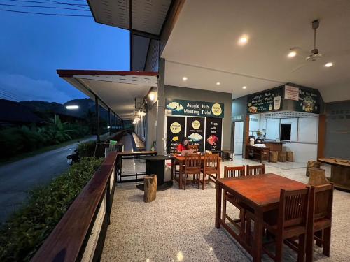 ein Restaurant mit einem Tisch und Stühlen auf einer Straße in der Unterkunft Khao Sok Jungle Hostel in Khao Sok