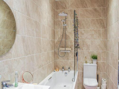 ein Badezimmer mit einer Dusche, einem WC und einer Badewanne in der Unterkunft The Seaside Suite in Helensburgh