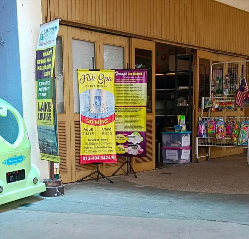 un negozio con cartelli sul lato di un edificio di Yussal Homestay a Simpang Ampat Semanggol