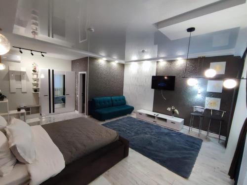 a bedroom with a large bed and a blue couch at Zest hotel & spa in Uralsk