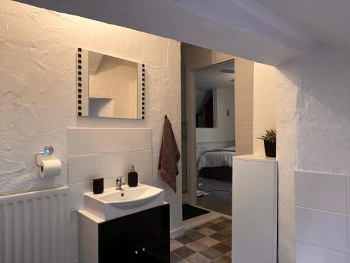 ein Bad mit einem Waschbecken und einem Spiegel in der Unterkunft Historic Grade 2 listed, Town centre, St.Neots Cambridgeshire in Hail Weston