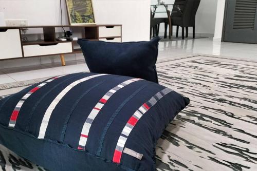 un lit avec un oreiller bleu et blanc sur un tapis dans l'établissement IRIS 33 Corner Lot House Spacious Outdoor Malay Only, à Skudai
