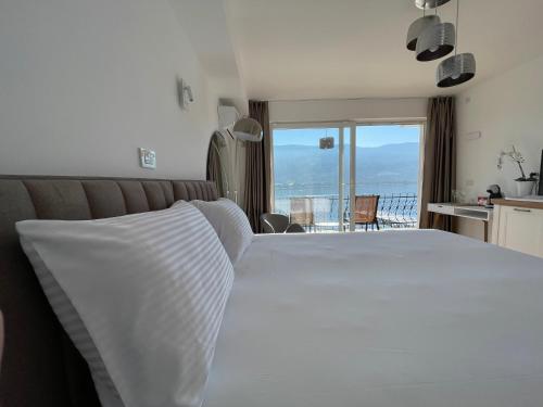 a bedroom with a large white bed with a view at Villa Una in Ohrid