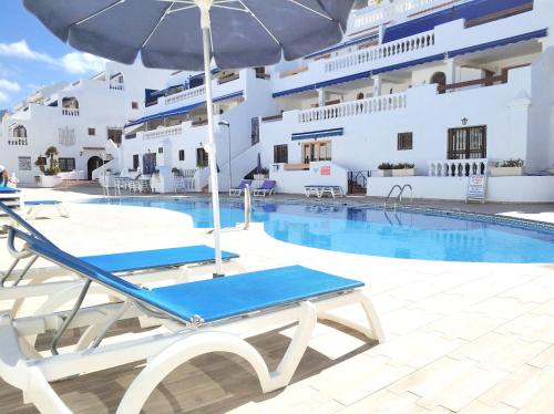una piscina con una silla y una sombrilla junto a un crucero en SEAVIEW PORT ROYAL, Los Cristianos, Heated Pool, WiFi, en Los Cristianos