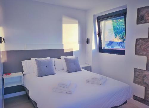 uma cama branca num quarto com uma janela em De Sebastian 1 - estudio frente al mar em San Nicolás