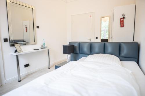een slaapkamer met een bed en een spiegel bij VILLA BOWDY in Niederzier