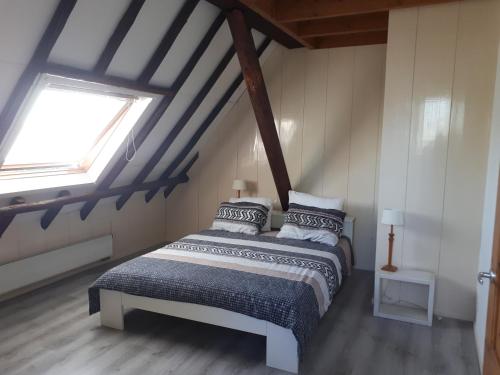 een slaapkamer met een bed op zolder bij Gastenverblijf Boerengeluk 