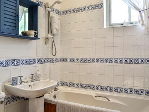 a bathroom with a sink and a bath tub at Milnfield Cottage in Annan