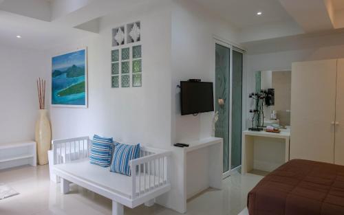 um quarto branco com uma cama e uma televisão na parede em Baan Poon Garden em Chaweng