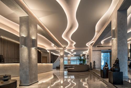 a lobby of a building with columns and ceilings at Petinos Hotel in Platis Yialos Mykonos