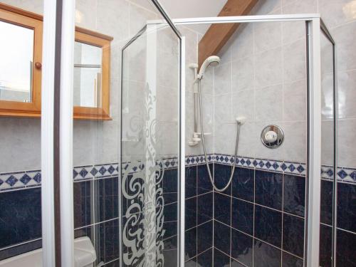 a glass shower in a bathroom with black and white tiles at Coachmans Lodge - Uk35952 in South Pool