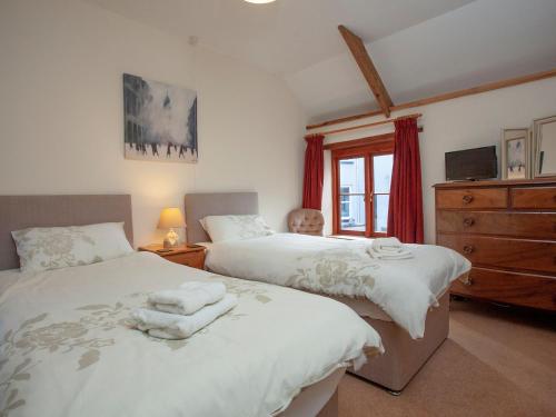 a bedroom with two beds and a dresser at Coachmans Lodge - Uk35952 in South Pool
