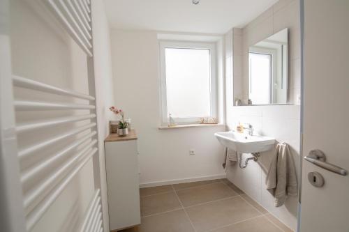 a white bathroom with a sink and a mirror at Vineyards Pommern - schönes Ferienhaus Nähe Cochem Mosel in Pommern
