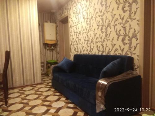 a blue couch in a living room with a wallpaper at Caspian Star in Sumqayyt