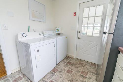 ein Badezimmer mit einer Waschmaschine und einer weißen Tür in der Unterkunft Seaside in Guilford