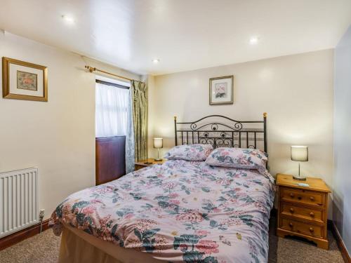 a bedroom with a bed and two lamps and a window at The Granary in Poulton le Fylde