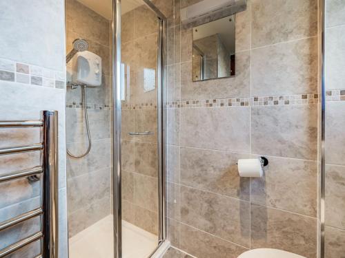 a bathroom with a shower with a toilet and a mirror at The Granary in Poulton le Fylde