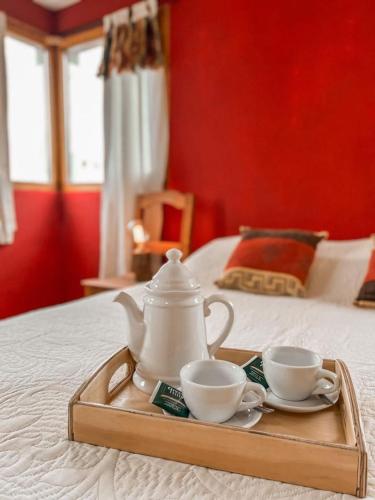bandeja con 2 tazas y set de té en una cama en Diente de León en Trevelín