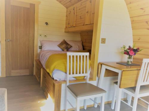 a small bedroom with a bed and a desk at Burnbank Glamping Pod in Acharacle