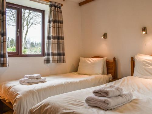 two beds in a room with towels on them at May Cottage-uk38279 in Cloughton