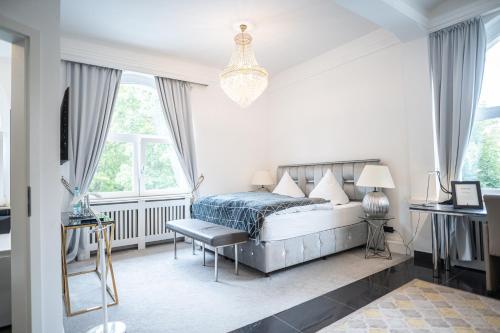 een slaapkamer met een bed en een kroonluchter bij VILLA BOWDY in Niederzier