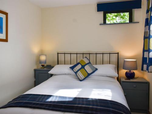 a bedroom with a white bed with two pillows at Red Gable Cottage in Shap