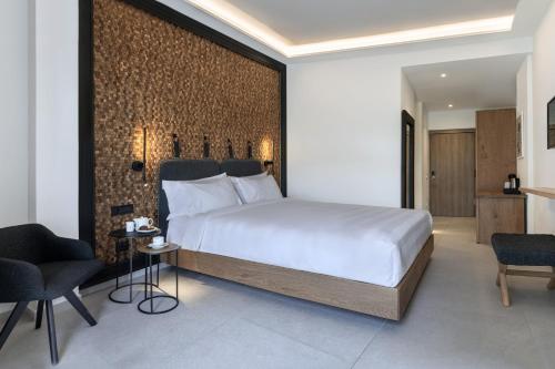 a bedroom with a large bed and a brick wall at Petinos Hotel in Platis Gialos