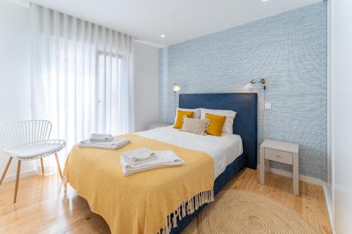 ein Schlafzimmer mit einem großen Bett und einer gelben Decke in der Unterkunft T1 Aquamar in Nazaré