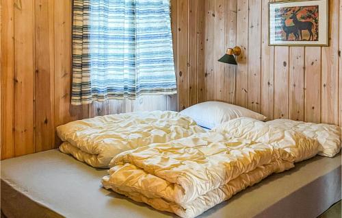 Bett in einem Zimmer mit einer Holzwand in der Unterkunft Cozy Home In Hovden I Setesdalen With Kitchen in Hovden