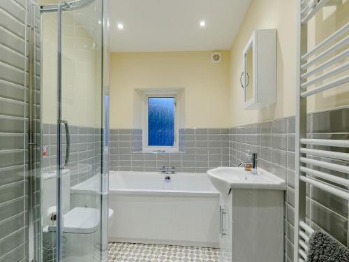 a bathroom with a tub and a sink and a shower at Vine Cottage in Broadstairs