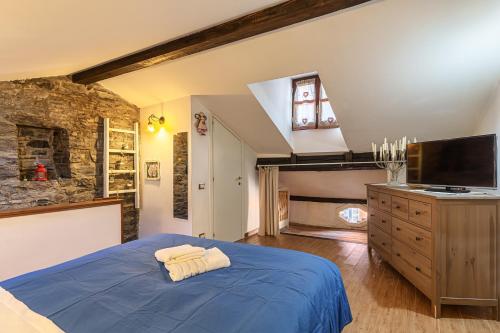 a bedroom with a blue bed and a flat screen tv at Casa al Lago di Como in Riva Cernobbio in Cernobbio