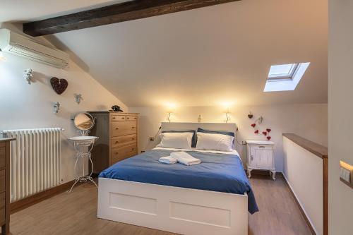 a bedroom with a bed with blue sheets and a window at Casa al Lago di Como in Riva Cernobbio in Cernobbio