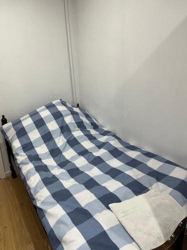 a blue and white bed in a room at Comfortable single bedroom with free on site parking in Kingston upon Thames