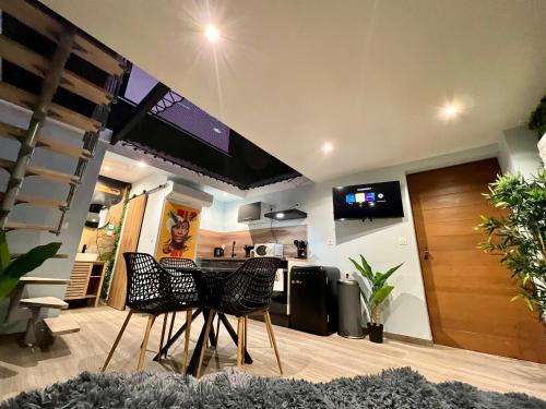 a kitchen with two chairs and a table and a counter at Capsule Safari - Jacuzzi - Nintendo Switch - Netflix & Home cinéma - Pouf géant - Filet suspendu in Douai