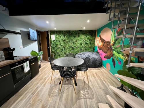 cocina con mesa y sillas en una habitación en Capsule Safari - Jacuzzi - Nintendo Switch - Netflix & Home cinéma - Pouf géant - Filet suspendu, en Douai