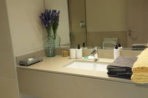 een badkamerbar met een wastafel en een spiegel bij Deluxe Apartment on YAS with Sea View Balcony in Abu Dhabi